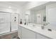 Modern bathroom showcasing a sleek vanity, large mirror, and a glass-enclosed shower at 1212 Solace Way, Rolesville, NC 27571