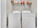 Bright laundry room with white washer and dryer beneath wire shelving for storage at 1312 Regulator St, Raleigh, NC 27603