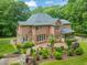 Picturesque brick home with a manicured yard, brick patio, and mature landscaping, creating a private outdoor oasis at 1317 Woodgate Manor Ct, Raleigh, NC 27614