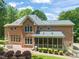 Expansive brick home featuring screened porch, brick patio, and landscaped backyard with mature trees at 1317 Woodgate Manor Ct, Raleigh, NC 27614