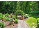 Beautifully landscaped backyard featuring stone path, colorful plantings and lush green trees at 1317 Woodgate Manor Ct, Raleigh, NC 27614