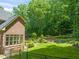 Landscaped backyard featuring a brick house with lush greenery and a fenced garden at 1317 Woodgate Manor Ct, Raleigh, NC 27614