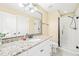 Well-lit bathroom featuring a granite vanity and enclosed shower at 1317 Woodgate Manor Ct, Raleigh, NC 27614
