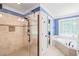 Elegant bathroom featuring a large walk-in shower and a separate soaking tub under a window at 1317 Woodgate Manor Ct, Raleigh, NC 27614