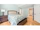 Comfortable bedroom featuring a large bed, hardwood floors, and soft, natural light at 1317 Woodgate Manor Ct, Raleigh, NC 27614