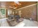 Brick porch with dining table and chairs, fan and light fixture on the ceiling and brick wall at 1317 Woodgate Manor Ct, Raleigh, NC 27614