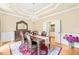 Elegant dining room features a chandelier, decorative mirror, and access to an open-concept kitchen at 1317 Woodgate Manor Ct, Raleigh, NC 27614