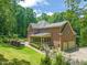 Brick home featuring a screened porch, 2 car garage, landscaped lawn, and mature trees at 1317 Woodgate Manor Ct, Raleigh, NC 27614