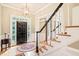 Inviting foyer featuring hardwood floors, staircase, and a stylish chandelier, creating a grand entrance at 1317 Woodgate Manor Ct, Raleigh, NC 27614