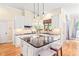 Bright, well-lit kitchen featuring a center island, modern lighting, and white cabinetry at 1317 Woodgate Manor Ct, Raleigh, NC 27614