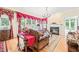 Cozy living room with a fireplace, large windows dressed with ornate curtains, and hardwood flooring at 1317 Woodgate Manor Ct, Raleigh, NC 27614