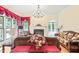 Inviting living room featuring a fireplace, large windows dressed with ornate curtains, and hardwood flooring at 1317 Woodgate Manor Ct, Raleigh, NC 27614