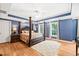 Elegant main bedroom with a four-poster bed, wood floors, and ample natural light at 1317 Woodgate Manor Ct, Raleigh, NC 27614