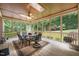 Inviting screened porch with wood floors, ceiling fan, skylight and views of the lush backyard at 1317 Woodgate Manor Ct, Raleigh, NC 27614