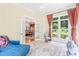 Bright sun room with a blue chaise lounge, lots of windows and an open doorway to the living room at 1317 Woodgate Manor Ct, Raleigh, NC 27614