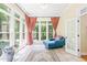 Bright sunroom with tile floors, multiple windows, and an inviting blue lounge chair at 1317 Woodgate Manor Ct, Raleigh, NC 27614