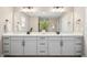 Bathroom featuring double sink vanity with modern fixtures, white cabinets and a large mirror at 137 Azalea View Way, Holly Springs, NC 27540
