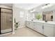Bright bathroom featuring a large vanity with dual sinks, a large mirror and a glass-enclosed shower at 137 Azalea View Way, Holly Springs, NC 27540