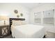 Bedroom featuring white walls, carpet floors, two windows, a lamp, and a dark wood bedframe at 137 Azalea View Way, Holly Springs, NC 27540