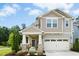 Charming two-story home with a two-car garage, covered porch, stone accents, and well-maintained landscaping at 137 Azalea View Way, Holly Springs, NC 27540