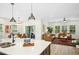 Open-concept living area with a kitchen island, dining area, and hardwood floors creating a welcoming space at 137 Azalea View Way, Holly Springs, NC 27540
