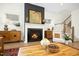 Cozy living room with a fireplace, hardwood floors, a decorative mantel, and a stylish accent wall at 137 Azalea View Way, Holly Springs, NC 27540