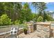 Outdoor kitchen area boasts a built-in grill and stone countertops, perfect for backyard entertaining at 137 Azalea View Way, Holly Springs, NC 27540