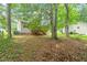 View of the home's exterior with a wooden deck, surrounded by mature trees and foliage at 1409 Beckworth Ct, Garner, NC 27529