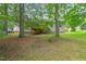 Exterior of the house with a wooden deck surrounded by mature trees, shrubs, and well-maintained lawn at 1409 Beckworth Ct, Garner, NC 27529