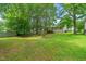 Expansive backyard featuring mature trees and lush green grass, perfect for outdoor activities and relaxation at 1409 Beckworth Ct, Garner, NC 27529