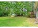 A spacious backyard with lush green grass and mature trees at 1409 Beckworth Ct, Garner, NC 27529