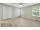 Bright bedroom with light wood floors, ceiling fan, windows, and white closets at 1409 Beckworth Ct, Garner, NC 27529