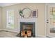 Close-up of fireplace featuring a marble hearth, round mirror, and modern decor at 1409 Beckworth Ct, Garner, NC 27529
