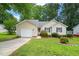 Charming single-story home with a well-maintained lawn, lush landscaping, and an attached garage at 1409 Beckworth Ct, Garner, NC 27529