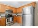 Kitchen with stainless steel appliances, wooden cabinets, and granite countertops at 1409 Beckworth Ct, Garner, NC 27529