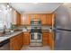 Well-lit kitchen featuring stainless steel appliances, wooden cabinets, and granite countertops at 1409 Beckworth Ct, Garner, NC 27529
