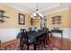 Dining room showcasing wainscoting, a black dining set and wood floors under chandelier lighting at 142 Crestline Dr, Selma, NC 27576