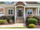 Inviting front entrance featuring a porch, brown door and manicured landscaping at 142 Crestline Dr, Selma, NC 27576