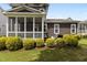 Rear exterior view showing a screened porch, grill, and manicured shrubs at 1508 Heritage Reserve Ct, Wake Forest, NC 27587