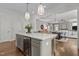 Open-concept kitchen features a wine cooler, marble countertops, and stylish pendant lighting overlooking the living room at 1508 Heritage Reserve Ct, Wake Forest, NC 27587