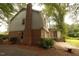 Backyard showing the rear of the house, chimney, patio, and lush trees at 1513 Western Ave, Rocky Mount, NC 27804