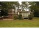 Backyard view of home with exterior porch and lush surrounding trees at 1513 Western Ave, Rocky Mount, NC 27804