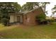 Backyard view of home featuring a red brick facade and lush yard at 1513 Western Ave, Rocky Mount, NC 27804
