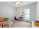 Bright bedroom with a ceiling fan, neutral paint, and desk with chair by the window at 1819 Umstead Rd, Durham, NC 27712