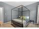 Bedroom featuring a canopy bed, grey walls, neutral carpet and a side table with lamp at 1819 Umstead Rd, Durham, NC 27712