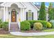 Inviting front porch with lush landscaping, brick steps, and black-trimmed windows create a welcoming entrance at 1819 Umstead Rd, Durham, NC 27712