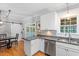 Kitchen with white cabinets, granite countertops, stainless appliances and view to dining area at 1819 Umstead Rd, Durham, NC 27712