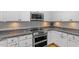 Kitchen with stainless double oven, gray backsplash, and white cabinetry at 1819 Umstead Rd, Durham, NC 27712