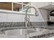 Close-up of kitchen sink with granite countertops and tile backsplash at 1819 Umstead Rd, Durham, NC 27712