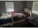 Shared bedroom with two twin beds, ample natural light from the window and closet storage at 2037 Swepsonville Rd, Graham, NC 27253